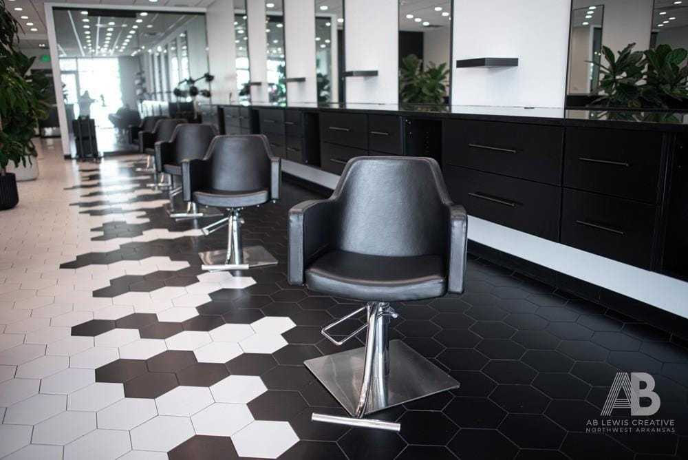 Modern salon with sleek black chairs and stylish hexagon tile flooring.